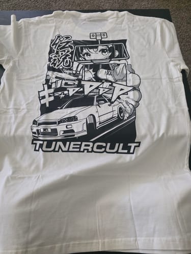 Customer's white graphic Mystery Tee, showing the back design with a car and an anime character.