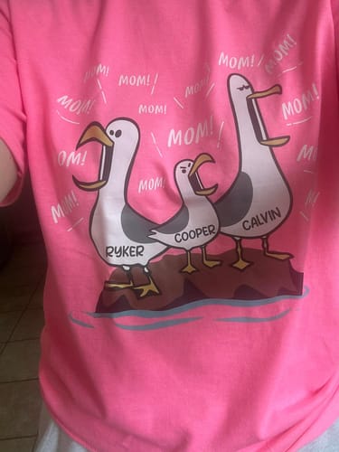 Reviewer wearing the pink personalized Seagull Mom shirt with the names Ryker, Cooper, and Calvin.