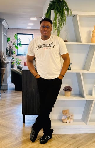 Customer posing indoors wearing black Vortex Cargo Stacked Denim, showing the full length and stacked fit.