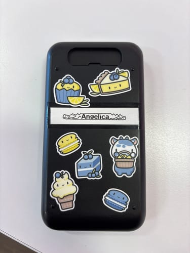 Reviewer's cute dessert-themed stickers from the Sticker Subscription on a black phone case.