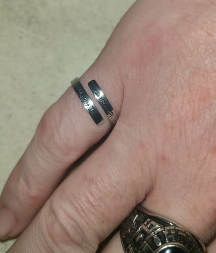 Close-up of a customer's hand wearing the engraved, silver-colored I F♡cking Love You Ring.