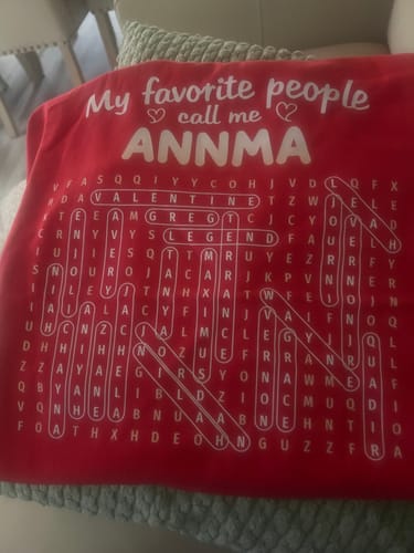 Customer's red personalized word search shirt with 'ANNMA' and circled names in the puzzle.