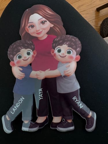 Customer's personalized acrylic magnet showing a cartoon grandma named Yaya being hugged by two grandkids, Landon and Ryan.