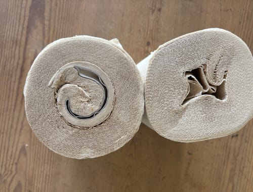 Customer's photo of two damaged Unbleached Bamboo Kitchen Rolls with crushed, misshapen centers.