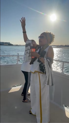 Reviewer on a boat wearing the white Contrast Color Two Pieces Set while waving under the sun.