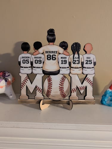 Customer's personalized wooden plaque spelling 'MOM' with a baseball 'O', showing a mom and five kids in custom jerseys on top.
