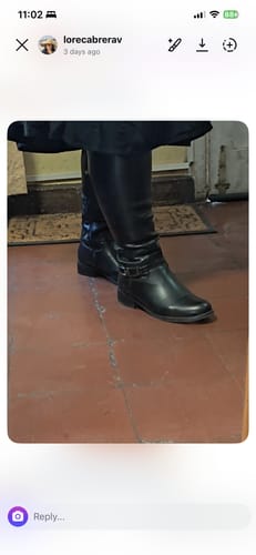 Una clienta usando sus botas negras de caña alta Tania Lux en interior.