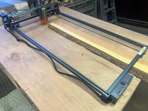 Customer's laser engraving kit for long items set up on a wooden table.