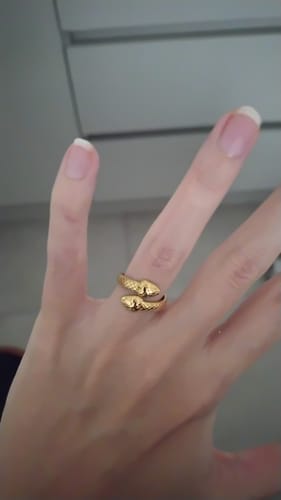 Cliente mostrando el Anillo Ajustable Leila dorado, con forma de serpiente, en su mano.