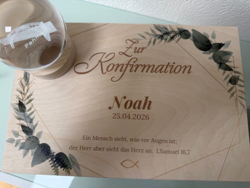 Ein Kunde zeigt die personalisierte Erinnerungskiste aus Holz zur Konfirmation, bedruckt mit Namen, Datum und einem Bibelvers.