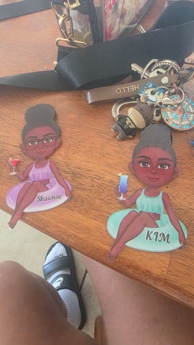 Customer's two personalized 'Girl on Float' cruise magnets with the names 'Shaunae' and 'KIM' shown on a wooden surface.