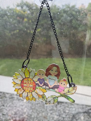 Customer's personalized 'Best Mom Ever' sunflower suncatcher with figures of a mom and kids hanging on a window.