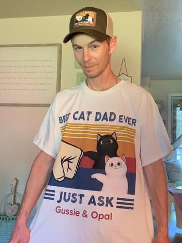 Customer wearing their personalized 'Best Cat Dad Ever' t-shirt with a fist bump graphic and the names Gussie & Opal.