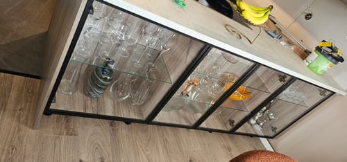 Anmelderens glasskap som bruker Sanremo Eik Natur kontaktplast som en dekorativ bakvegg for glass.