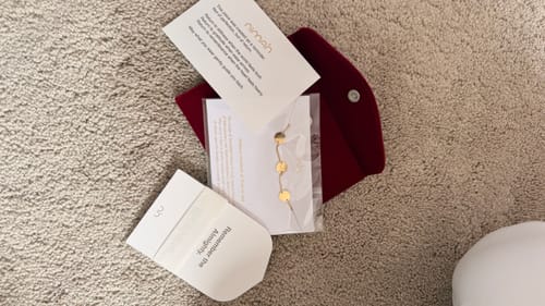 Customer's red velvet Jewellery Travel Pouch shown with its beautiful packaging and a bracelet.