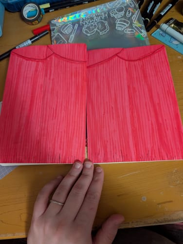 Reviewer holding open the Movie Night Mini Journal, showing inner pages designed to look like closed red theater curtains.