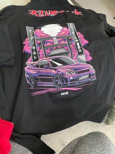 Customer shows a black hoodie from the mystery box with a large graphic of a purple car and a Japanese gate.