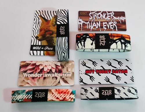 Customer displays four different wristbands and their matching collector cards from the Non-Interactive Mystery 3-Pack.
