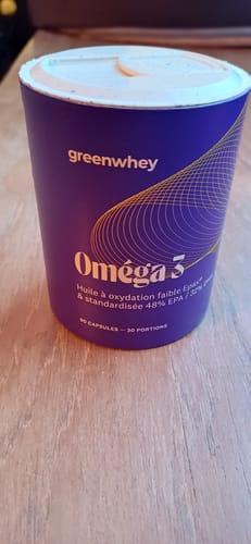 Le petit pot violet d'Oméga 3 EPAX® d'un client, posé sur une table en bois.