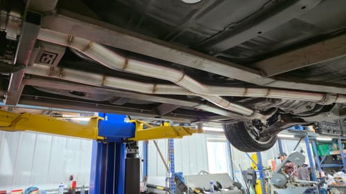Customer's view of a custom stainless steel exhaust on a car, fabricated using EdgeCore Ceramic Sanding Belts.