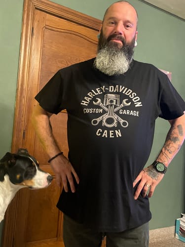 Un client portant le T-shirt Custom Garage noir, avec le logo Harley-Davidson.