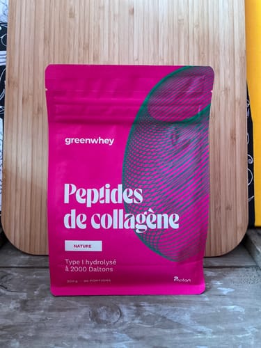 Le sachet rose vif des Peptides de Collagène d'un client, saveur nature, posé sur une table en bois.