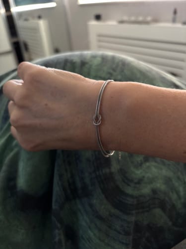 Reviewer wearing the silver Forever Knot Bracelet on their wrist.