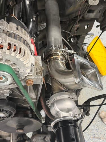 Customer's High Flow Wastegate Merge installed in an engine bay, showing the connection to the wastegate and exhaust piping.