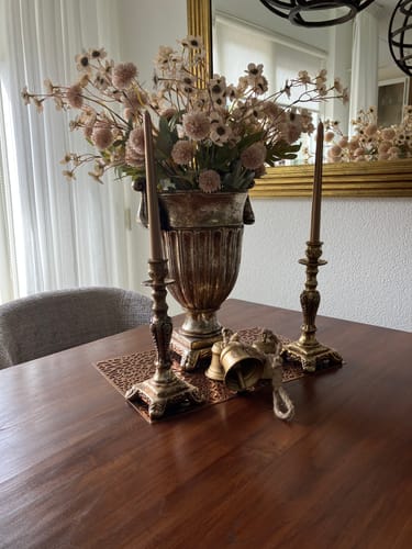 Recensent toont het Wax Arrangement - Crème in een grote, sierlijke vaas op een eettafel.
