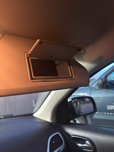 Customer's SPOTMINDERS Tracking Card tucked into the vanity mirror of a car's sun visor.