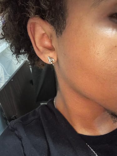 Close-up of a reviewer wearing the silver ANGEL EARRING stud in their ear.