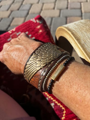 Customer wearing their engraved Rectangle Bead Bracelet, layered on the wrist with a wide leather bracelet.