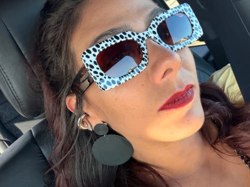 Close-up of a reviewer wearing the Spot Me If You Can Mixed Print Sunglasses in a car.
