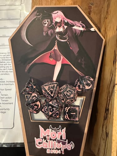 Customer's Mori Calliope Black Shattered Glass Dice Set displayed inside its coffin-shaped collectible box with character art.