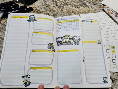 Reviewer's journal spread showing a weekly planner decorated with fun llama and lemonade stand stickers from the subscription.