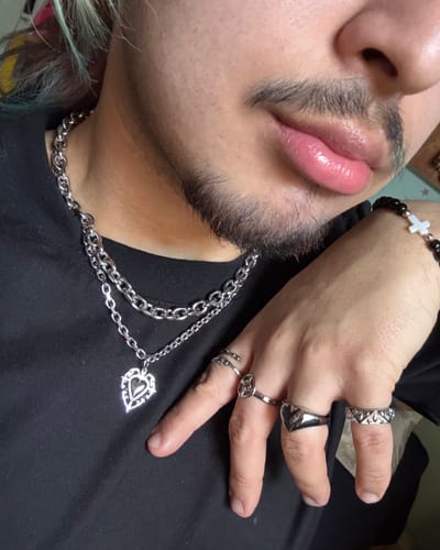 Customer's close-up of the silver ARIES CHAIN layered with another necklace against a black shirt.