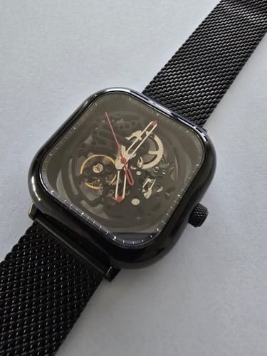 Primer plano del reloj Ciga Design C Series Skeleton de un cliente, con su esfera visible y correa de malla negra.