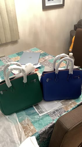 Customer's two new Warkin Bags, one green and one blue, on a table with handles still wrapped.
