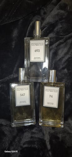 Customer's three 100ml Perfume Set bottles, numbers 74, 547, and 463, arranged on a dark plush surface.