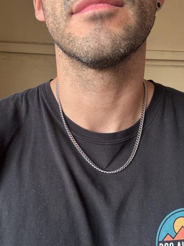 Primer plano de un cliente luciendo la Cadena Miami Cuban de 5mm sobre una camiseta oscura.