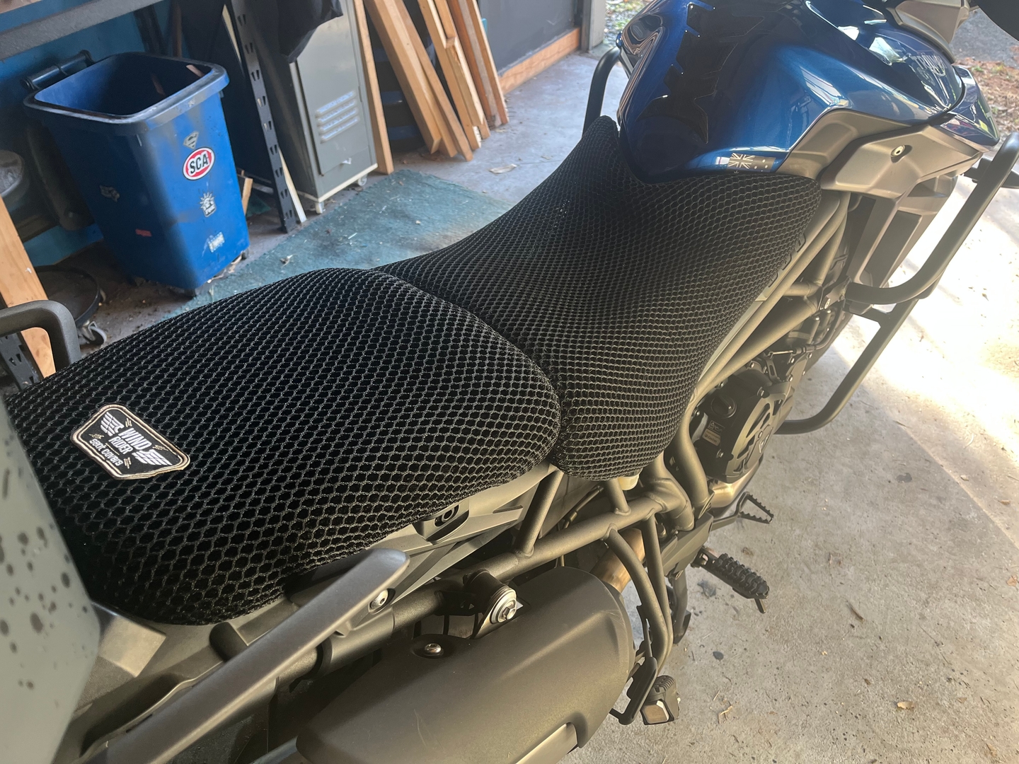Wind Rider 3D mesh seat cover fitted over the seat of a metric cruiser, full bike visible in a garage