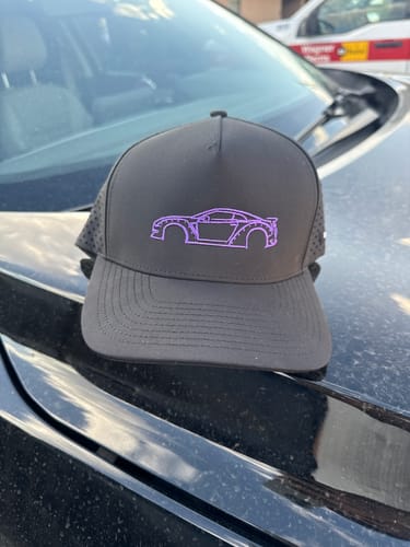 Customer's black 80Eighty DCG88 Hat with a purple embroidered car outline, shown resting on the hood of a car.