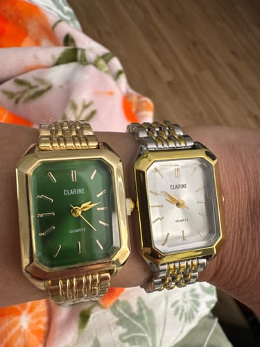 Customer wearing two CLAIRE DE MAINS watches on their wrist, one gold with a green dial and one two-toned.