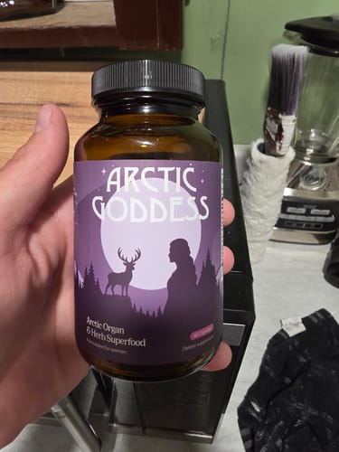 Reviewer holding the bottle of Arctic Goddess Reindeer Organ Superfood supplement.
