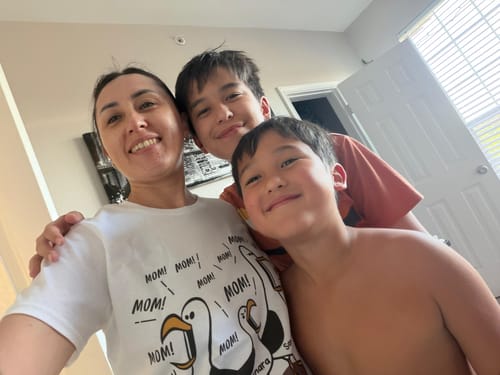 Reviewer smiling with two children while wearing the white 'Seagull Mom Mom Mom' personalized shirt.