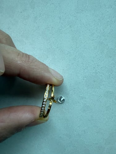 Customer holds the gold Princess Ring, showing the detached center stone next to the empty setting.