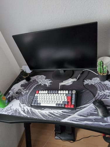 Kunde zeigt das große RZ Mousepad Kangawa Black auf einem eingerichteten Schreibtisch.