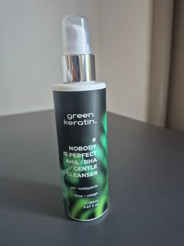 Photo d'un client montrant le flacon-pompe du nettoyant visage NOBODY IS PERFECT.
