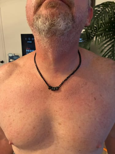 Customer wearing the black Legacy Necklace with several small beads around their neck.