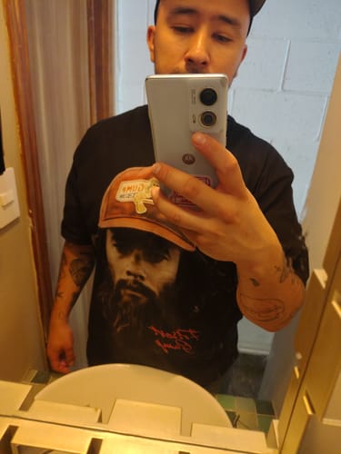 Cliente tomándose una selfie en el espejo para mostrar su camiseta negra Run Forrest.